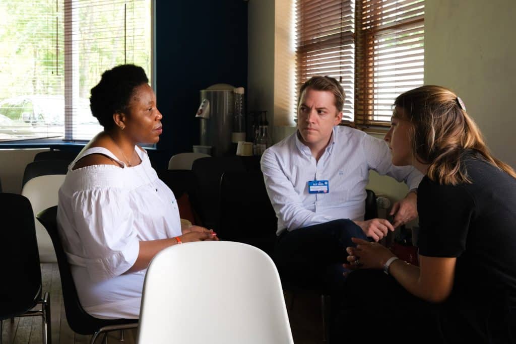 Des collaborateurs d’entreprise échangent avec une bénéficiaire d’association dans un moment de partage, organisé dans le cadre du séminaire engagé pour les équipes de Doctolib.