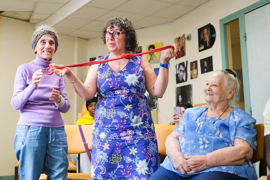 Une collaboratrice d’entreprise improvise avec deux personnes âgées du centre d’accueil Delta7 lors d’un team building de théâtre organisé par Lutila.