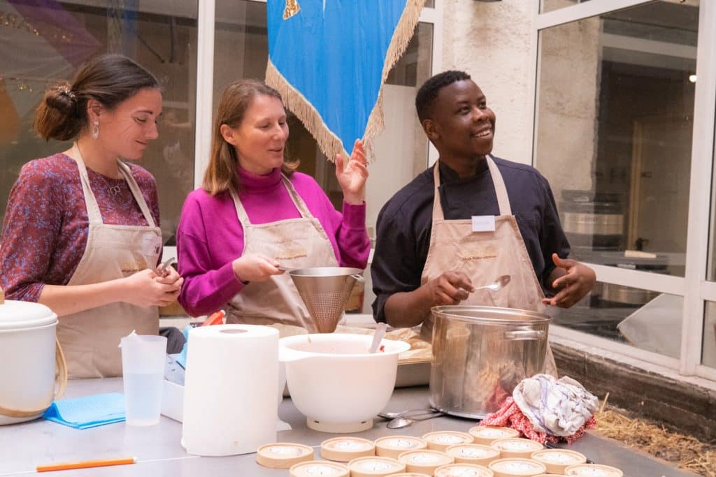 Trois collaborateurs rient aux éclats lors d’un atelier de cuisine solidaire, réalisé dans le cadre d’un séminaire organisé par Lutila.