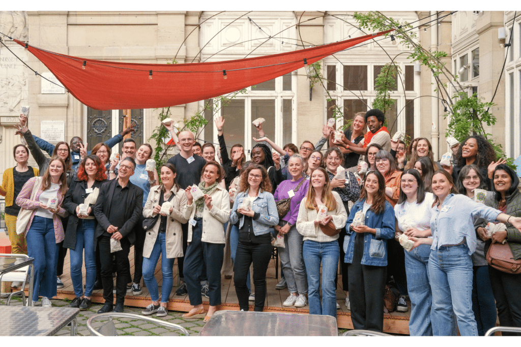 Des collaborateurs d’entreprise prennent la pose dans une photo de groupe à l’Académie du Climat à Paris, dans le cadre d’un séminaire solidaire organisé par Lutila.