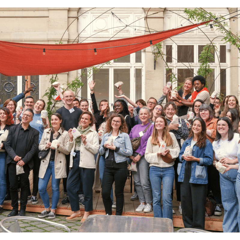 Des collaborateurs d’entreprise prennent la pose dans une photo de groupe à l’Académie du Climat à Paris, dans le cadre d’un séminaire solidaire organisé par Lutila.