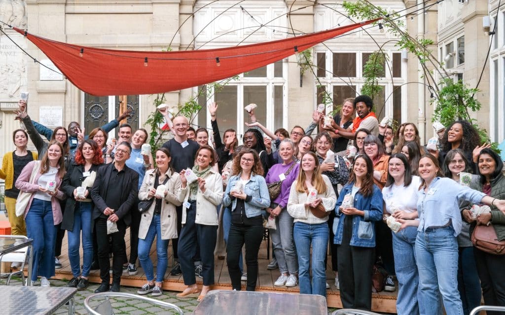 Des collaborateurs d’entreprise prennent la pose dans une photo de groupe à l’Académie du Climat à Paris, dans le cadre d’un séminaire solidaire organisé par Lutila.